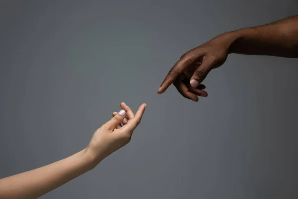 Расовая терпимость. Уважайте социальное единство. Африканские и кавказские руки жестом изолированы на сером фоне студии — стоковое фото