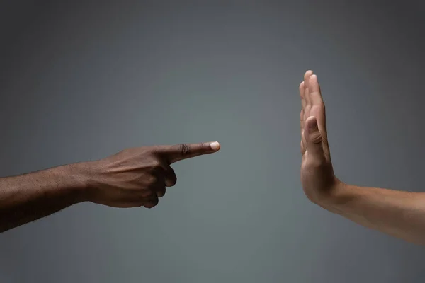 Raciale tolerantie. Respecteer de sociale eenheid. Afrikaanse en Kaukasische handen gebaren geïsoleerd op grijze studio achtergrond — Stockfoto