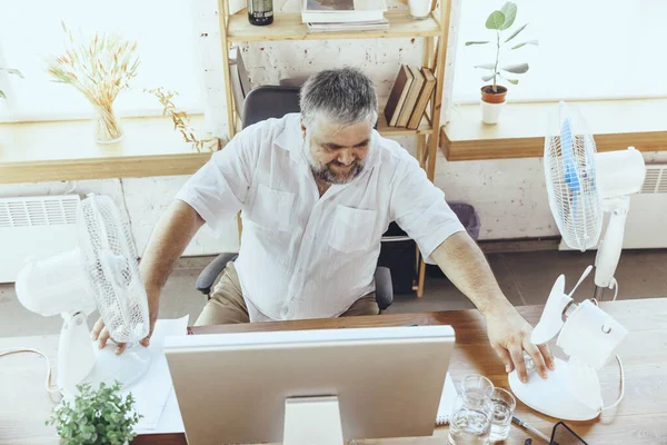 Empresario, gerente en la oficina con computadora y ventilador enfriándose, sintiéndose caliente, enrojecido — Foto de Stock