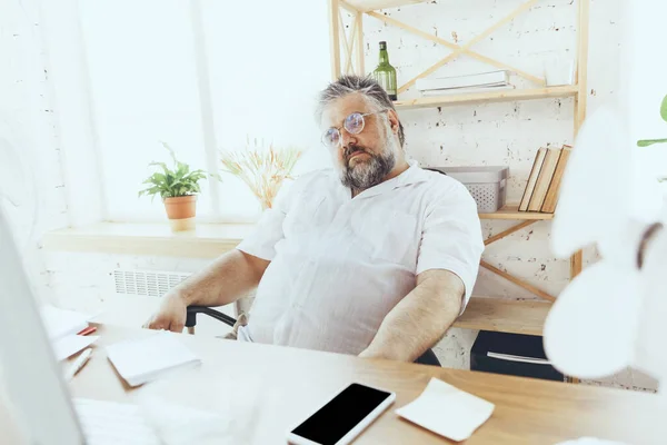Бизнесмен, менеджер в офисе с компьютером и вентилятором охлаждается, чувствует себя горячим, покраснел — стоковое фото
