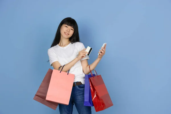 Portrait of young asian woman isolated on blue studio background — Stock Photo, Image