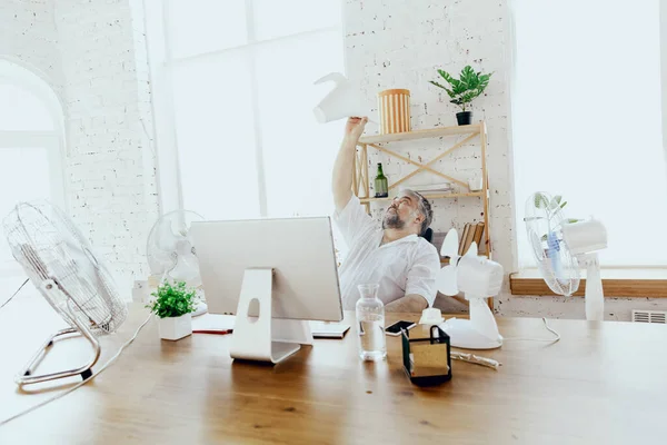 Empresario, gerente en la oficina con computadora y ventilador enfriándose, sintiéndose caliente, enrojecido — Foto de Stock