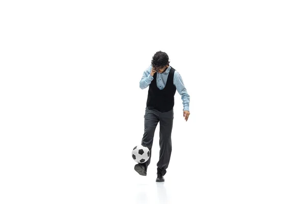 Uomo in abiti da ufficio giocare a calcio o calcio con la palla su sfondo bianco. Look insolito per uomo d'affari in movimento, azione. Sport, stile di vita sano. — Foto Stock