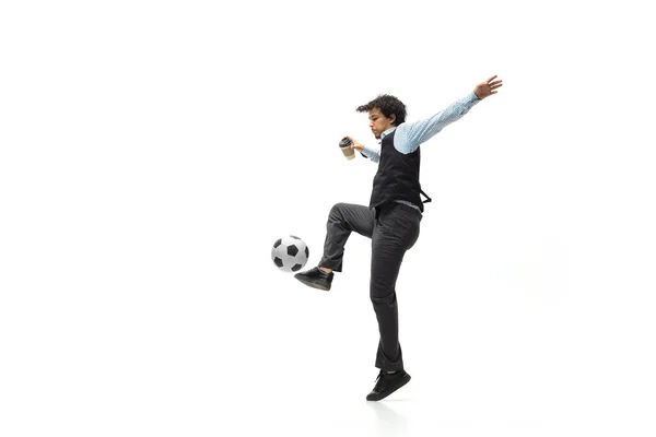 Uomo in abiti da ufficio giocare a calcio o calcio con la palla su sfondo bianco. Look insolito per uomo d'affari in movimento, azione. Sport, stile di vita sano. — Foto Stock
