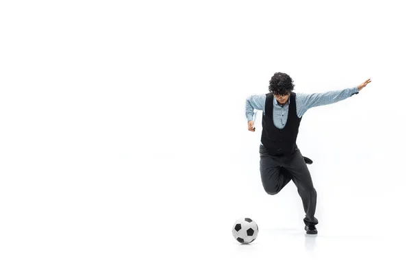 Homme en vêtements de bureau jouant au football ou au football avec un ballon sur fond blanc. Regard inhabituel pour l'homme d'affaires en mouvement, l'action. Sport, mode de vie sain. — Photo