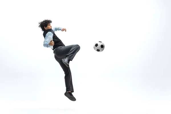 Homem em roupas de escritório jogando futebol ou futebol com bola no fundo branco. Um olhar incomum para o homem de negócios em movimento, ação. Desporto, estilo de vida saudável . — Fotografia de Stock