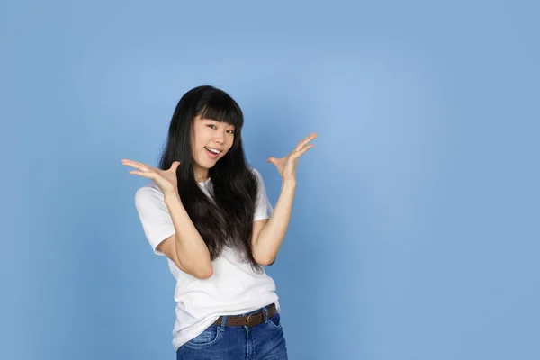 Portrait of young asian woman isolated on blue studio background — Stock Photo, Image