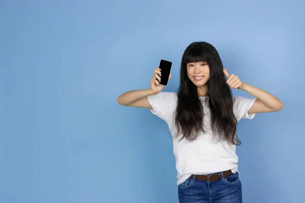 Portrét mladé asijské ženy izolované na modrém pozadí studia — Stock fotografie