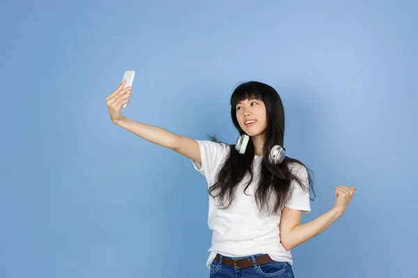 Portrét mladé asijské ženy izolované na modrém pozadí studia — Stock fotografie