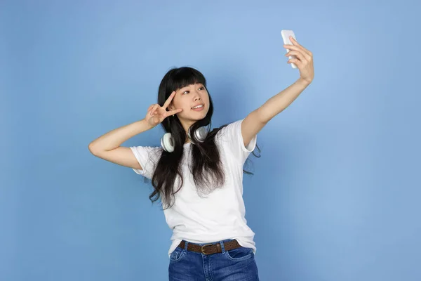 Portrét mladé asijské ženy izolované na modrém pozadí studia — Stock fotografie