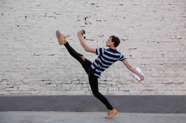 Binaların önünde zıplayan genç buinessman, koşuyor yüksek atlama