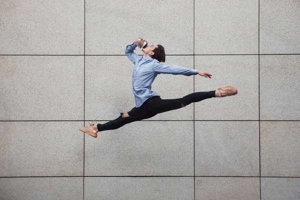 Стрибки молодого процвітаючого перед будівлями, на бігу високо в стрибках — стокове фото