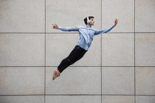 Saltando jovem buinessman na frente de edifícios, em fuga em salto alto — Fotografia de Stock