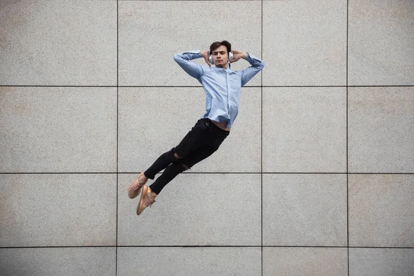 Jumping young buinessman in front of buildings, on the run in jump high — Stock Photo, Image