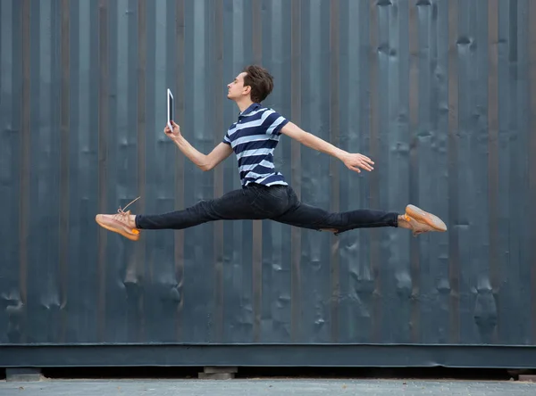 Jumping young buinessman in front of buildings, on the run in jump high — Stock Photo, Image