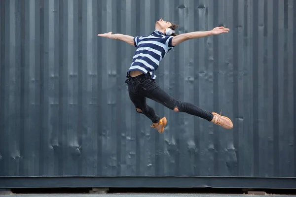 Springen jonge buinessman in de voorkant van gebouwen, op de vlucht in hoog springen — Stockfoto