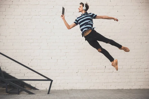 Jumping young buinessman in front of buildings, on the run in jump high — Stock Photo, Image