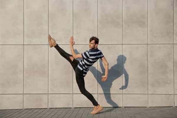 Jumping young buinessman in front of buildings, on the run in jump high — Stock Photo, Image