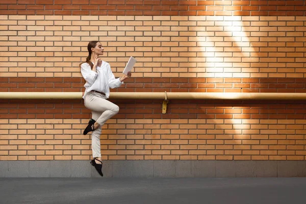 Saltando joven mujer en frente de los edificios, en la carrera en salto de altura — Foto de Stock