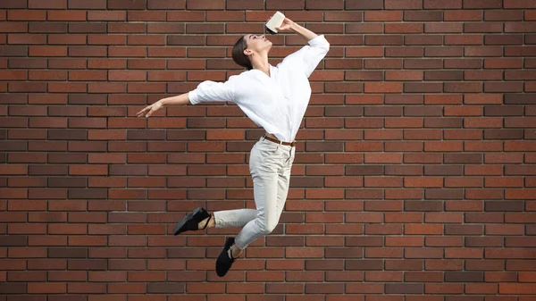Saltando jovem mulher na frente de edifícios, em fuga em salto alto — Fotografia de Stock