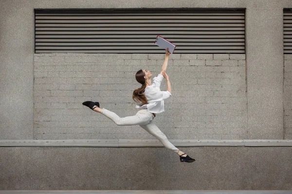 Salto giovane donna davanti agli edifici, in fuga in salto in alto — Foto Stock