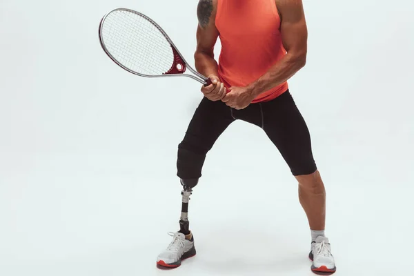 Atleta con discapacidad o amputado aislado en el fondo blanco del estudio. Jugador de tenis masculino profesional con entrenamiento de prótesis de pierna y práctica en estudio . — Foto de Stock