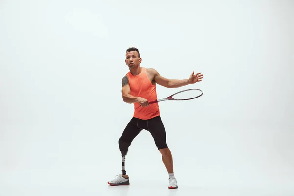 Atleta con discapacidad o amputado aislado en el fondo blanco del estudio. Jugador de tenis masculino profesional con entrenamiento de prótesis de pierna y práctica en estudio . —  Fotos de Stock