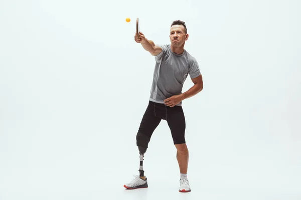 Athlète handicapé ou amputé isolé sur fond de studio blanc. Joueur professionnel de tennis de table avec entraînement par prothèse de jambe et pratique en studio. — Photo