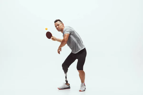 Athlète handicapé ou amputé isolé sur fond de studio blanc. Joueur professionnel de tennis de table avec entraînement par prothèse de jambe et pratique en studio. — Photo