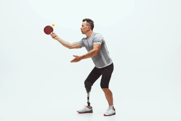 Athlète handicapé ou amputé isolé sur fond de studio blanc. Joueur professionnel de tennis de table avec entraînement par prothèse de jambe et pratique en studio. — Photo