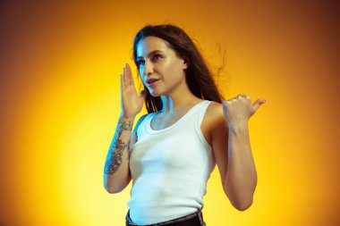 Beyaz tenli genç bir kadının portresi. Gradyan sarı arka planda izole edilmiş.