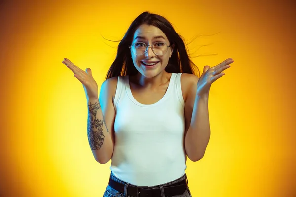 Portrait of young caucasian woman isolated on gradient yellow studio background — Stock Photo, Image