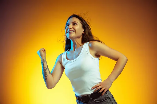 Portrait of young caucasian woman isolated on gradient yellow studio background — Stock Photo, Image