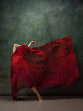 Koyu yeşil stüdyo arka planında zarif bir balerin.