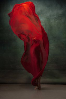 Koyu yeşil stüdyo arka planında zarif bir balerin.