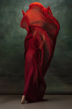 Koyu yeşil stüdyo arka planında zarif bir balerin.