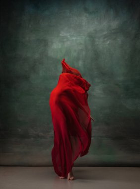 Koyu yeşil stüdyo arka planında zarif bir balerin.