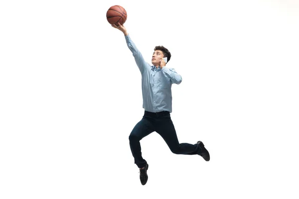 Man i kontorskläder spelar basket på vit bakgrund. Ovanligt utseende för affärsman i rörelse, handling. Sport, hälsosam livsstil. — Stockfoto