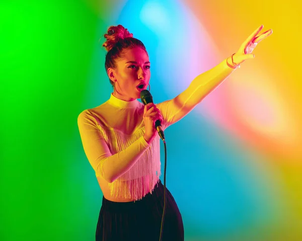 Jonge Kaukasische muzikant speelt, zingt op gradiënt achtergrond in neon licht. Concept van muziek, hobby, festival — Stockfoto