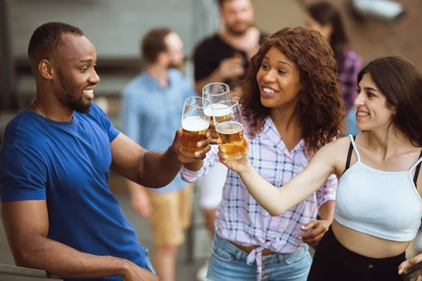 Grupo de amigos felices teniendo una fiesta de cerveza en el día de verano. Descansando juntos al aire libre, celebrando y relajando, riendo. Estilo de vida de verano, concepto de amistad . — Foto de Stock