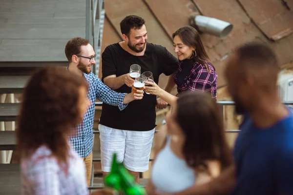 Grupo de amigos felices teniendo una fiesta de cerveza en el día de verano. Descansando juntos al aire libre, celebrando y relajando, riendo. Estilo de vida de verano, concepto de amistad . — Foto de Stock