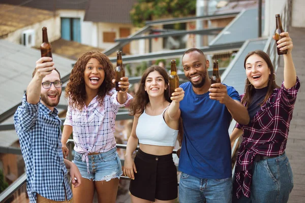 Gruppe fröhlicher Freunde, die an einem Sommertag Bier trinken. Gemeinsam im Freien ausruhen, feiern und entspannen, lachen. Sommerlicher Lebensstil, Freundschaftskonzept. — Stockfoto