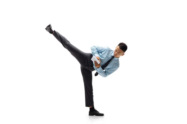 Homem em roupas de escritório praticando taekwondo em fundo branco. Um olhar incomum para o homem de negócios em movimento, ação. Desporto, estilo de vida saudável . — Fotografia de Stock