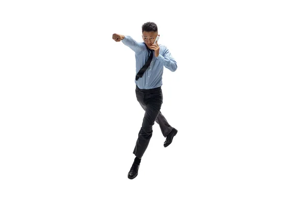Muž v kancelářských šatech cvičí taekwondo na bílém pozadí. Neobvyklý pohled obchodníka v pohybu, akce. Sport, zdravý životní styl. — Stock fotografie