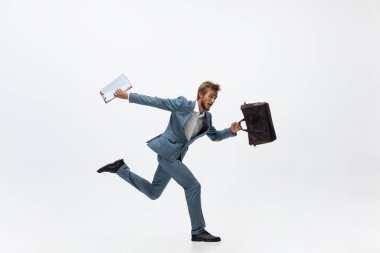 Ofis elbiseli bir adam koşuyor, beyaz arka planda koşuyor. Hareket halindeki bir iş adamı için alışılmadık bir görünüm. Spor, sağlıklı yaşam tarzı.