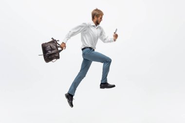 Ofis elbiseli bir adam koşuyor, beyaz arka planda koşuyor. Hareket halindeki bir iş adamı için alışılmadık bir görünüm. Spor, sağlıklı yaşam tarzı.