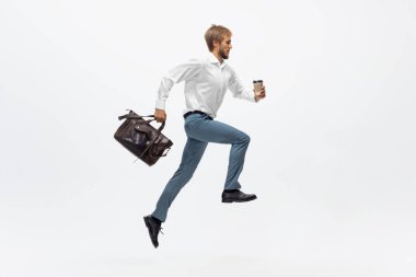 Ofis elbiseli bir adam koşuyor, beyaz arka planda koşuyor. Hareket halindeki bir iş adamı için alışılmadık bir görünüm. Spor, sağlıklı yaşam tarzı.