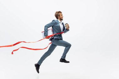 Ofis elbiseli bir adam koşuyor, beyaz arka planda koşuyor. Hareket halindeki bir iş adamı için alışılmadık bir görünüm. Spor, sağlıklı yaşam tarzı.