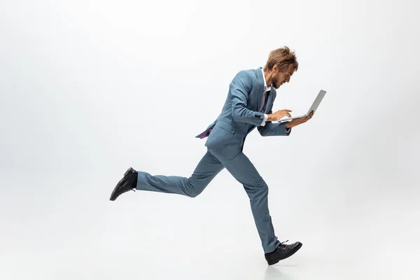 Homem de roupa de escritório a correr, a correr sobre fundo branco. Um olhar incomum para o homem de negócios em movimento, ação. Desporto, estilo de vida saudável . — Fotografia de Stock