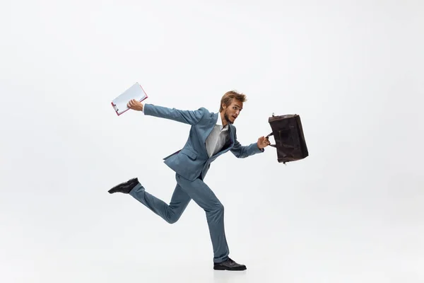 オフィスの服を着た男が走って白い背景をジョギングしている。動き、行動のビジネスマンのための異常な外観。スポーツ、健康的なライフスタイル. — ストック写真